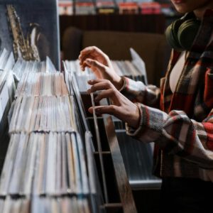 A person browses through a selection of vinyl records in a vintage music shop.