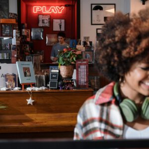 Woman enjoying music in a vintage record store with vibrant decor.