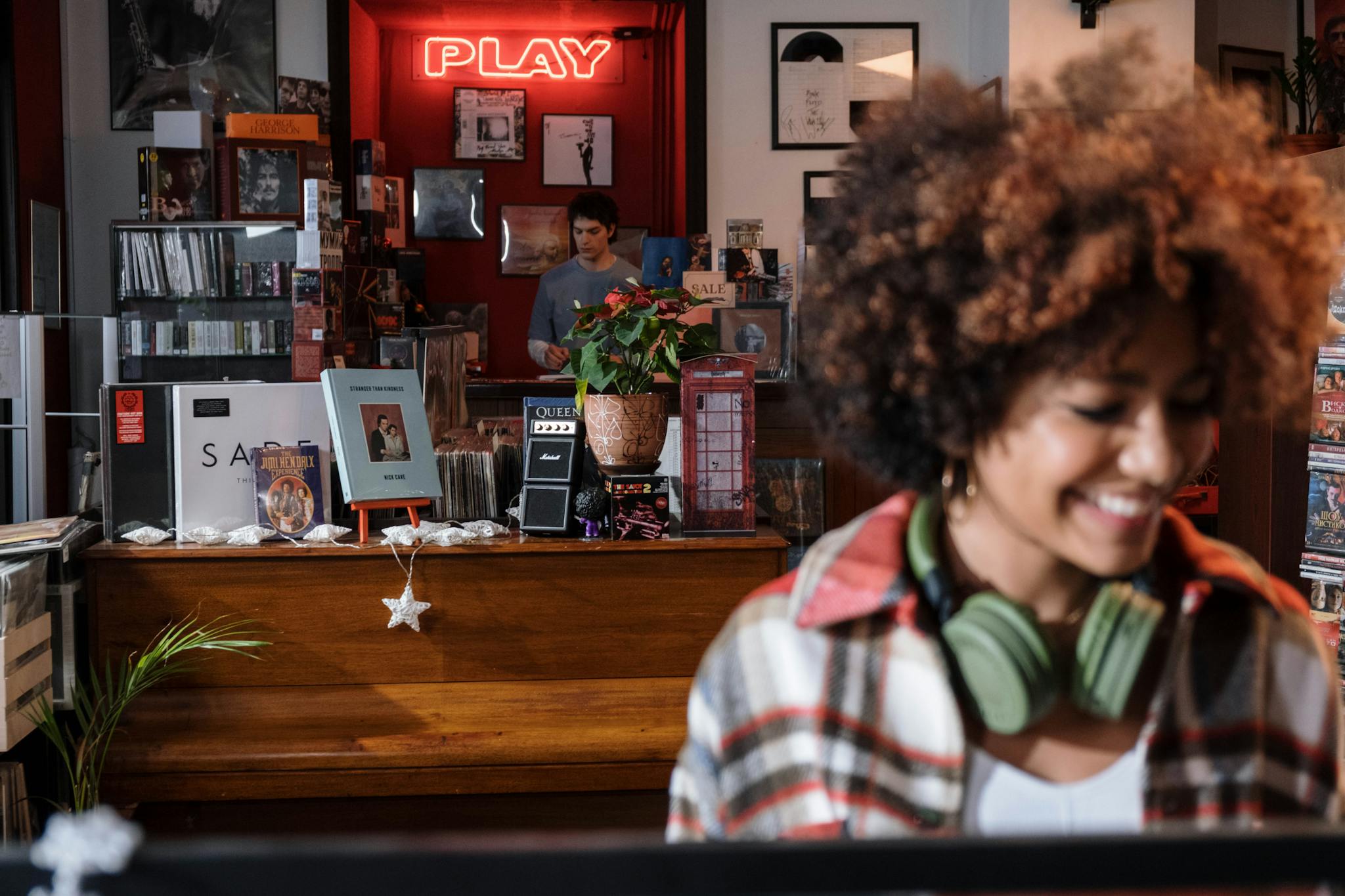 Woman enjoying music in a vintage record store with vibrant decor.